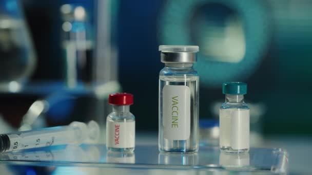 Glazen Injectieflacons Met Een Vaccin Een Spuit Een Wazig Laboratoriumachtergrond — Stockvideo