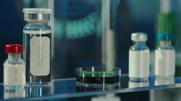 Injektionsflaskor Glas Med Vaccin Och Petriskål Med Grön Substans Blå — Stockvideo