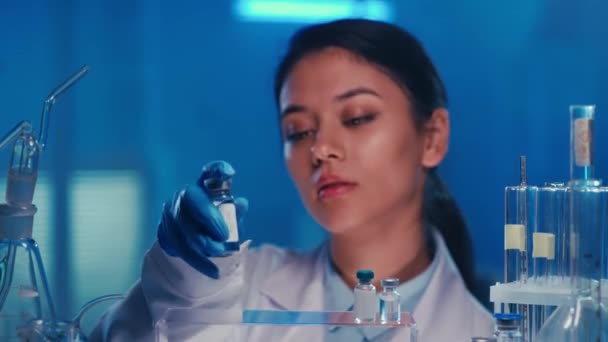 Asiatisk Kvinnlig Läkare Tar Injektionsflaska Med Vaccin Från Hylla Och — Stockvideo