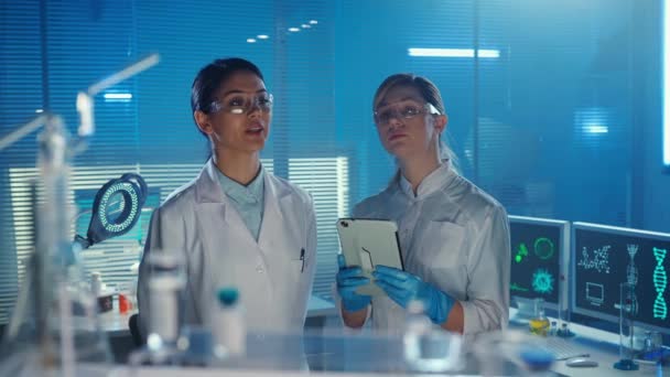 一名亚洲女医生负责盘点或订购药品 而一名助手则将数据输入数字平板电脑 身穿白色医疗服的多族裔妇女 玻璃实验室或医院 — 图库视频影像
