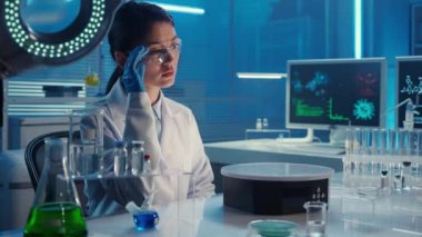 Koreli bir kadın doktor sanal grafikleri inceler, yakınlaştırır ve resmi geçirir. Beyaz önlüklü Asyalı kadın araştırmacı labaratuarda mavi ışıkla oturuyor. Biyokimyasal araştırma laboratuvarı. Yeriniz...