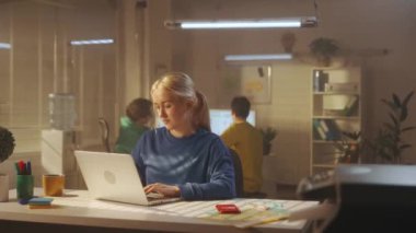 Mavi eşofmanlı genç bir kadın dizüstü bilgisayarda klavyeyle yazı yazıyor, sonra rahatlıyor, yapılan işten tatmin oluyor. Arka planda genç, yaratıcı bir yönetici ekibi çalışıyor. İş ve gençlik