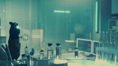 Yaşlı bir erkek doktor rafa el feneri tutar ve aşı ya da ilaç örneklerini çalar. Mavi ışıklı bir laboratuvar. Cam şişeler, mataralar ve test tüpleriyle dolu bir rafa bakın. Kapat.