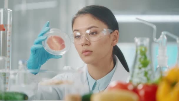 Young Asian Female Researcher Examines Sample Genetically Modified Meat Petri — Stock Video