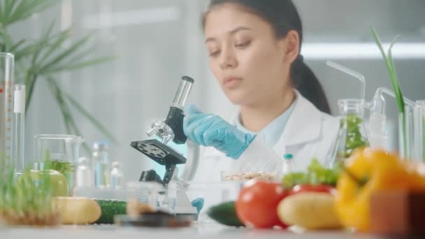 Uma Jovem Pesquisadora Asiática Examina Uma Biosamostra Sob Microscópio Microbiólogo — Vídeo de Stock