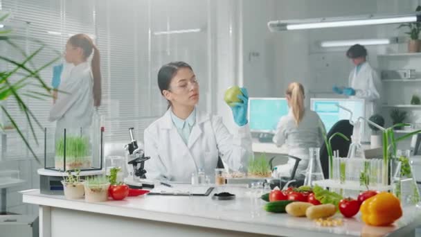 Ung Asiatisk Kvinnlig Biolog Undersöker Ett Prov Ett Grönt Äpple — Stockvideo