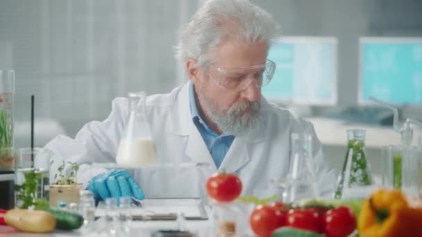 Yaşlı Erkek Araştırmacı Bir Süt Örneğini Inceler Veri Yazar Biyoteknoloji — Stok video