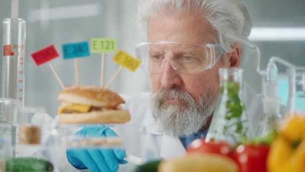 老年男性研究人员对一个标有E142 E240 E121和E160的汉堡包样本进行了检测 Biolog分析了样品的质量 对结果不满意 生物实验与食物和 — 图库视频影像
