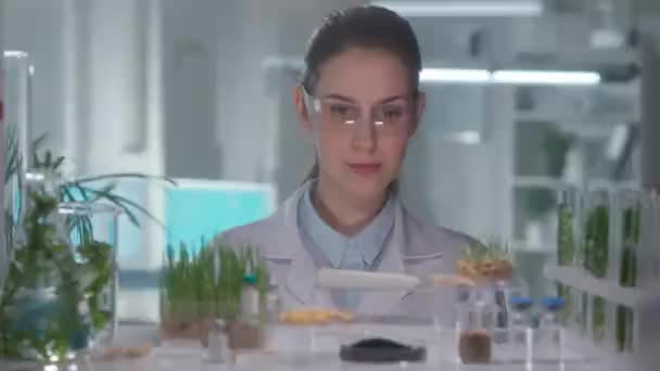 Female Researcher White Gown Goggles Looks Camera Smiles Grown Green — Stock Video