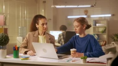 Orta yaşlı bir kadın lider genç bir bayan yöneticiyle yeni bir projeyi tartışıyor. Patron ofisteki bir masada otururken bir dizüstü bilgisayarda sunum yapar. Yönetim ekibi burada çalışıyor.