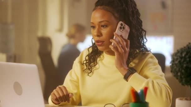 Mladá Afroameričanka Píše Klávesnici Notebooku Mluví Mobilního Telefonu Stolu Kanceláři — Stock video