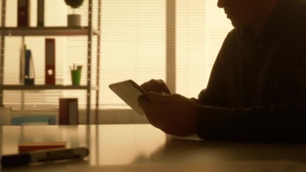 Bir Adamın Karanlık Silueti Dijital Tabletinin Ekranına Bilgi Aktarır Yakınlaştırır — Stok video