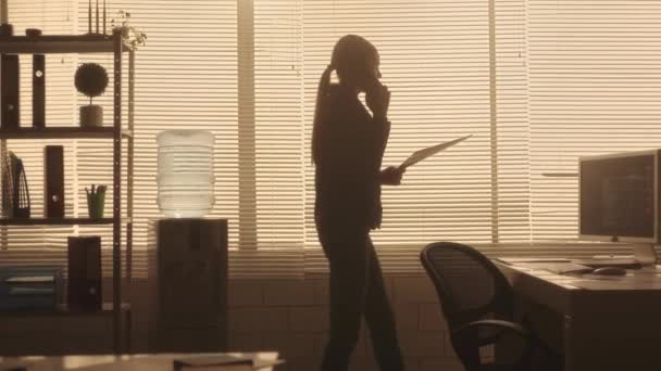 Silhouette Una Donna Sta Parlando Telefono Cellulare Guardando Attraverso Informazioni — Video Stock