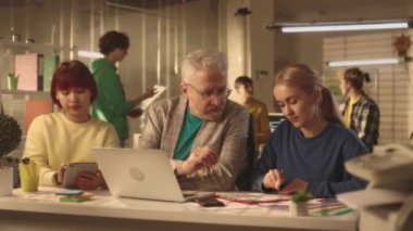 Yaşlı bir adam verileri genç bayan yöneticilerle kontrol eder. Avrupalı ve Asyalı ofis çalışanları masaya oturup yeni bir projeyi tartıştılar. Yöneticilerden oluşan genç bir yaratıcı ekip