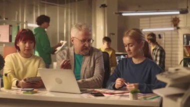 Yaşlı bir adam kadın yöneticilere rapordaki hatalar hakkında yorum yapar ve sinirlenir. Avrupalı ve Asyalı ofis çalışanları masada otururlar. Yöneticilerden oluşan genç bir yaratıcı ekip