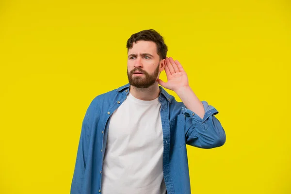 Young Serious Blond Man Blue Shirt Yellow Background Holding Ear — Stock Photo, Image