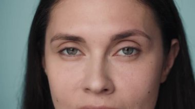 Genç bir kadının güzel gözleri. Mavi arka planda temiz ve sağlıklı bir cilde sahip bir kadının yüzünü kapatın. İyi görüş ve göz bakımı. Kontak lensler. Doğal kadın güzelliği