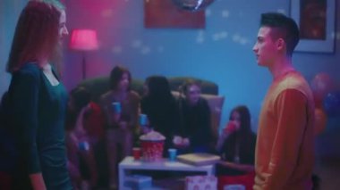 Yakışıklı sarışın kız erkekleri slow dansa davet etmeyi kabul ediyor. Bu arada bir grup arkadaşı kanepede dinleniyor, patlamış mısır yiyor, kağıt bardaklardan içki içiyor ve sohbet ediyorlar. Şey...