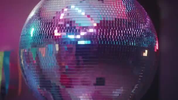 一个旋转的镜子迪斯科球闪烁着五彩缤纷的灯光 迪斯科舞会紧靠着房间的后面 晚会的音乐和舞蹈背景 — 图库视频影像