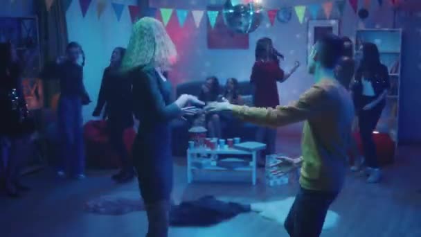 在晚会上 青少年们分成不同的小组跳舞 那个男的和那个女孩跳舞 远离了所有人 这家伙与那个女孩调情 庆祝活动 — 图库视频影像