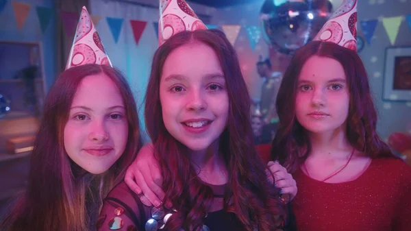 近照三个年轻姑娘头戴节日礼帽的少女女孩们摆姿势拍照 在一个家庭派对上自拍 家庭派对 生日的概念 — 图库照片