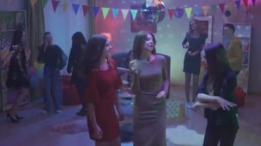 Partide gençler ayrı gruplar halinde dans ediyorlar. Üç kızdan oluşan bir grup ayrı dans ediyor, kızlar konuşuyor, gülümsüyor. Üç kız arkadaşın dansı. Parti, doğum günü, kutlama. HDR