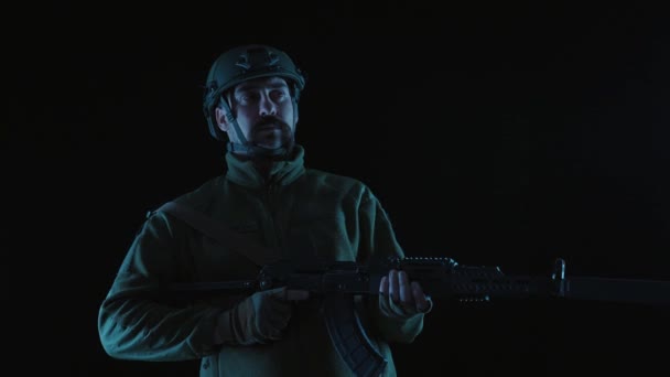 乌克兰士兵 黑色背景的卡拉什尼科夫冲锋枪近身 一名乌克兰士兵举起一支卡拉什尼科夫冲锋枪 俄罗斯军事入侵的概念 — 图库视频影像