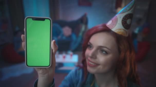 Rödhårig Flicka Festlig Hatt Visar Smartphone Med Grön Skärm Ler — Stockvideo