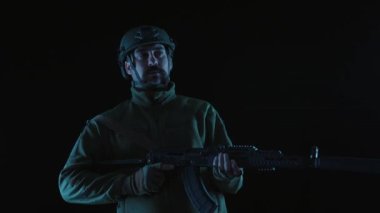 Siyah arka planda Kalaşnikof saldırı tüfeğiyle Ukrayna 'nın askeri. Bir Ukraynalı asker Kalaşnikof tüfeği kaldırdı, nişan aldı. Rus askeri işgali konsepti