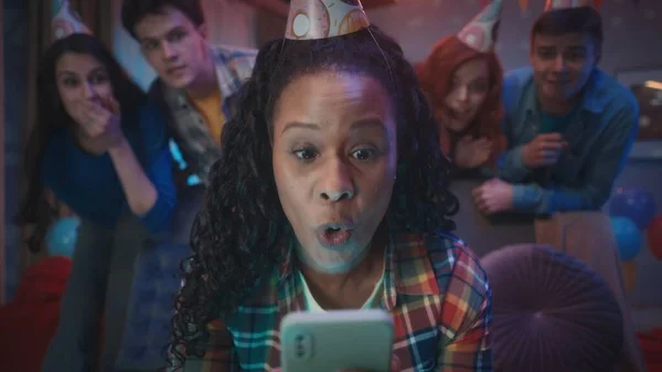 Afroamerykanka Świątecznym Kapeluszu Wygląda Zaskoczoną Zszokowaną Telefonem Dziewczyny Stoją Nią — Zdjęcie stockowe