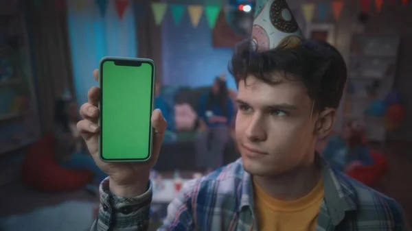 Şenlik Şapkalı Bir Adam Yeşil Ekranlı Akıllı Telefon Gösteriyor Bir — Stok fotoğraf
