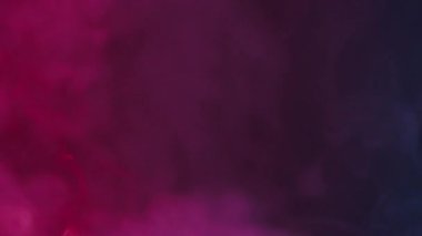 Dönen beyaz duman, pembe ve mavi neon ışıklarıyla aydınlatılan siyah bir arka plana doğru yükselir. Beyaz bulutlar, sis veya sis