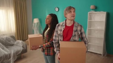 Yeni bir dairede ellerinde karton kutularla genç bir çift. Avrupalı bir adam ve Afrikalı bir Amerikalı kız yeni bir daireye taşınıyorlar, yeni evlerini incelemekten memnunlar. Gerçek satın alma