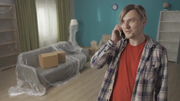 Mężczyzna Stojący Salonie Nowego Mieszkania Rozmawia Przez Telefon Portret Właściciela — Wideo stockowe