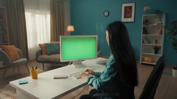 一个年轻的女人用智能手机讲完话 开始在有绿色屏幕的电脑上工作 绿色屏幕电脑显示器关闭 — 图库视频影像