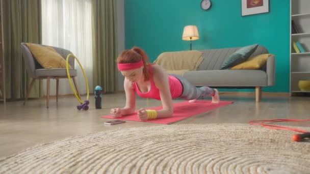 Uma Mulher Fato Desporto Rosa Deita Chão Frente Telefone Uma — Vídeo de Stock
