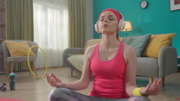 Una Joven Pelirroja Con Auriculares Sienta Posición Loto Medita Practica — Vídeos de Stock