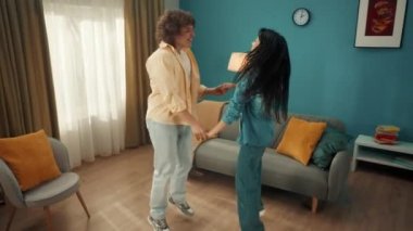 Kıvırcık bir adam ve genç bir Asyalı kadın izin günlerinde evde birlikte vakit geçiriyorlar. Genç çift eğleniyor, dans ediyor, zıplıyor, el ele tutuşuyor. Kapatın. Yavaş çekim