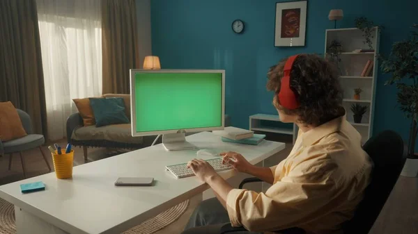 Genç Kıvırcık Adam Yeşil Ekranlı Bir Bilgisayarda Çalışıyor Masada Oturan — Stok fotoğraf