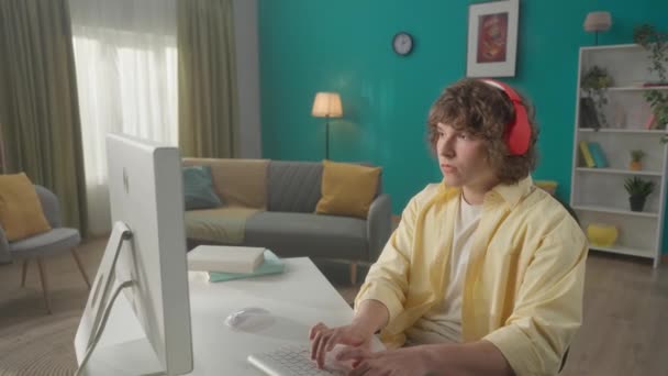 Mladík Sluchátkách Poslouchá Hudbu Zatímco Sedí Počítače Muž Luskne Prsty — Stock video