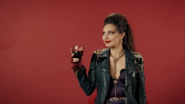 女性はワインのグラスで立って 彼女の目を撃ち 浮気し ワインを飲み 嘔吐します 唇を押すと悲しいことにカメラを覗き込む 赤い化粧をした女性の肖像 — ストック動画