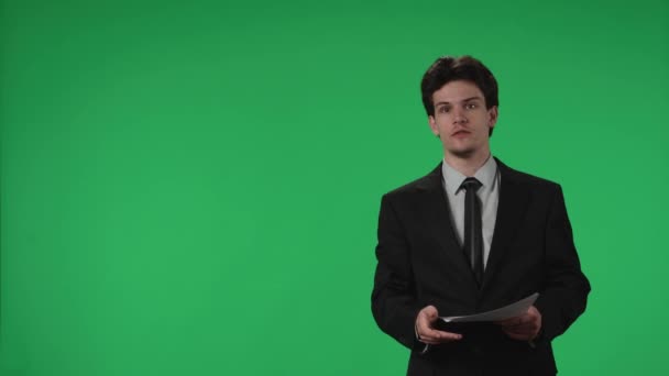 Élő Hírek Program Tévébemondó Papírokkal Kezében Egy Stúdióban Egy Zöld — Stock videók