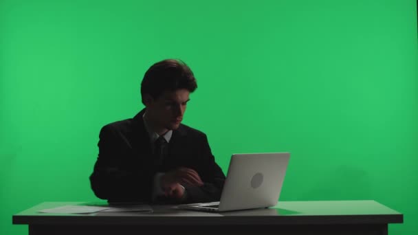 발표자는 어두운 스튜디오 탁자에 화면을 남자가 방송을 준비하고 프로그램 계획을 — 비디오