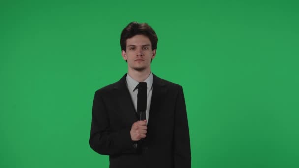 Ung Journalist Med Mikrofon Framför Grön Skärm Man Kostym Talar — Stockvideo