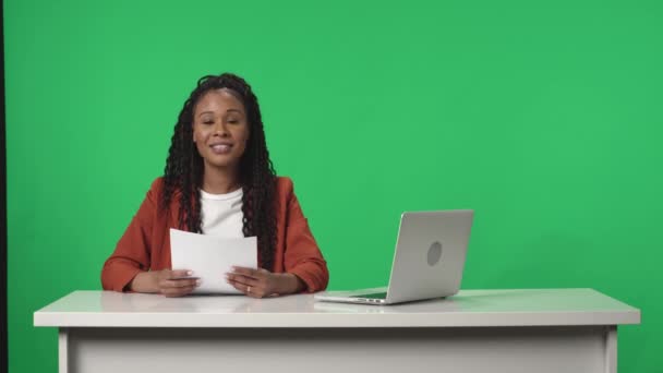 緑の画面の背景にプロのアンカー女性とライブニューススタジオ 報道が終わると女は報告書を書きノートパソコンを閉じて去るスタジオは暗闇へと突入する — ストック動画