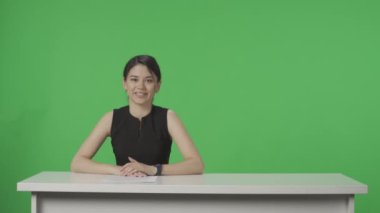 TV Canlı Haber Programı: Kadın Sunucu Muhabiri. Asyalı Anchorwoman konuşuyor, dinliyor, yeşil ekranın arka planına kafa sallıyor. Haber Odası Stüdyo Konsepti. Reklam alanı, çalışma alanı modeli. HDR