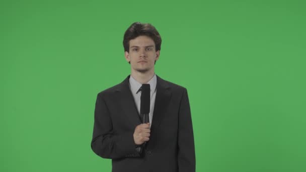 Fiatal Újságíró Mikrofonnal Zöld Vászon Előtt Egy Öltönyös Férfi Beszél — Stock videók