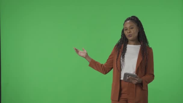 テレビ天気予報番組 アンコールウーマンはスタジオでタブレットを手に立っている アフリカ系アメリカ人の女性気象学者が緑色の画面を指している 広告エリア ワークスペースのモック Hdr Bt2020 — ストック動画