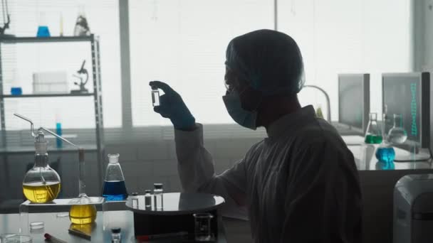 Исследование Разработка Вакцины Темный Силуэт Ученого Мужчины Стеклянной Ампулой Концепция — стоковое видео
