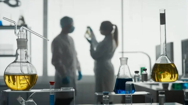 现代医学研究实验室 两位科学家一起分析了一个在艾伦迈耶瓶中的植物样本 讨论了结果 模糊的背景 高级医学实验室 — 图库照片